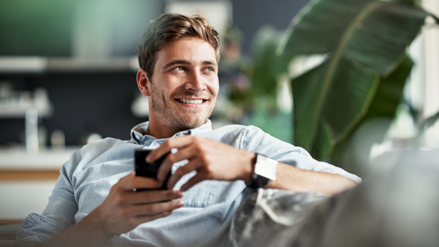 Smilende mann sjekker mobilen